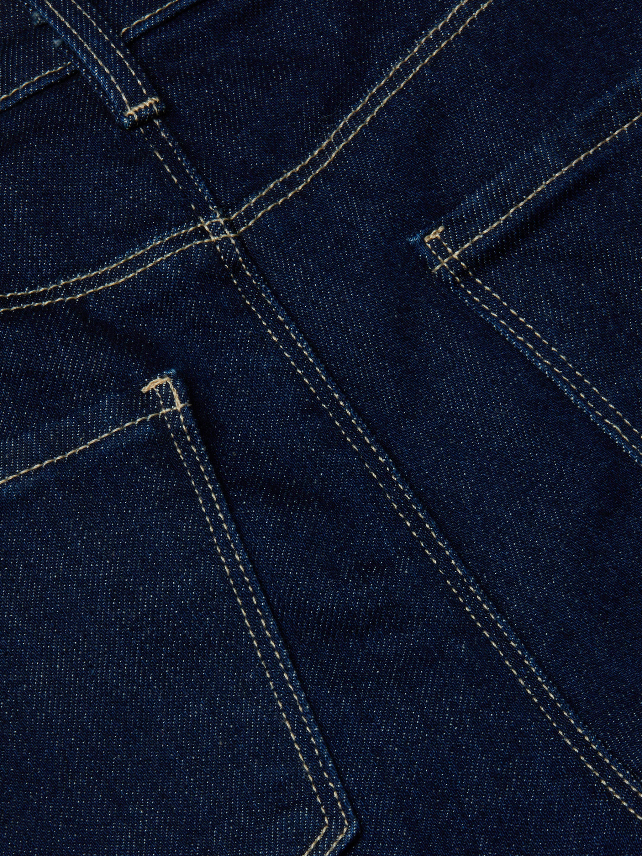 Close-up of the Clayton Wide-Leg Jean in dark wash denim, featuring two pockets and double-stitched yellow seams that showcase the fabric texture and construction details of this high-rise style.