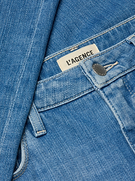 Close-up of the Clayton Wide-Leg Jean in blue denim, featuring a silver button, visible LAGENCE brand label, detailed stitching, and high rise stretch denim fabric.