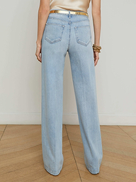 A person shown from the back with their hands by their sides, wearing the Clayton Wide-Leg Jean in a light wash and a gold belt, against a plain white background.