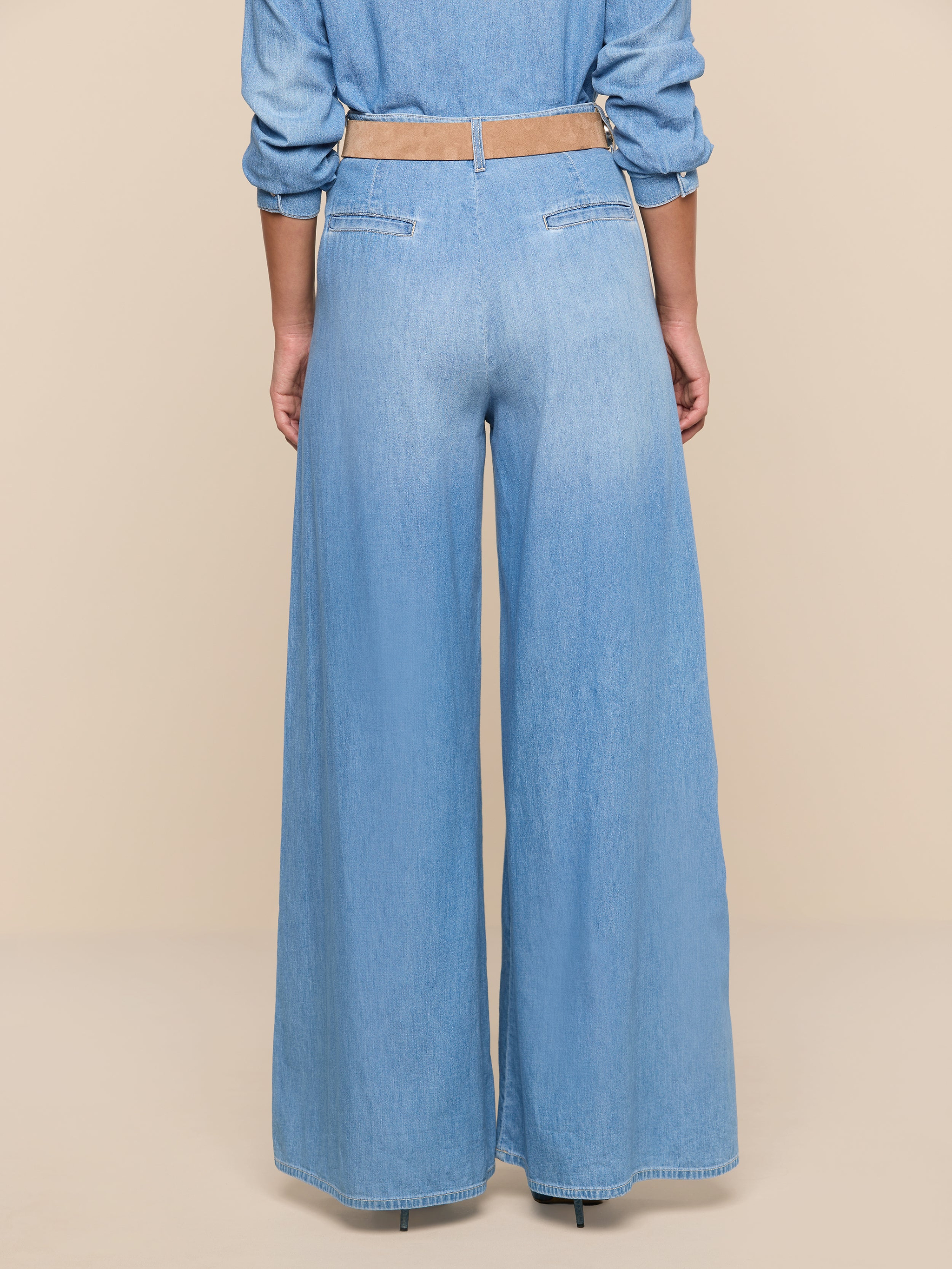 A person stands facing away, showcasing only the lower half of their body in the Lorenza Palazzo Jean against a plain white background.