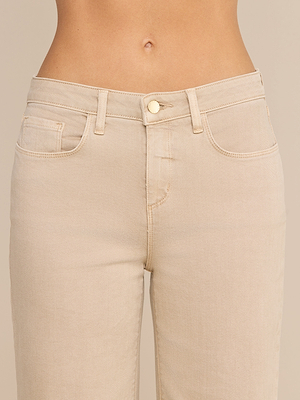 Nahaufnahme einer Person, die die „Alicent Wide-Leg Jean“ in Hellbeige trägt – mit hoher Leibhöhe und Knopf-Reißverschluss – von der Taille bis zu den Oberschenkeln vor einem neutralen Hintergrund.
