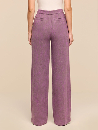 Woman wearing the Livvy Straight-Leg Trouser in purple herringbone and a sleeveless beige top, shown from the back against a plain beige background.