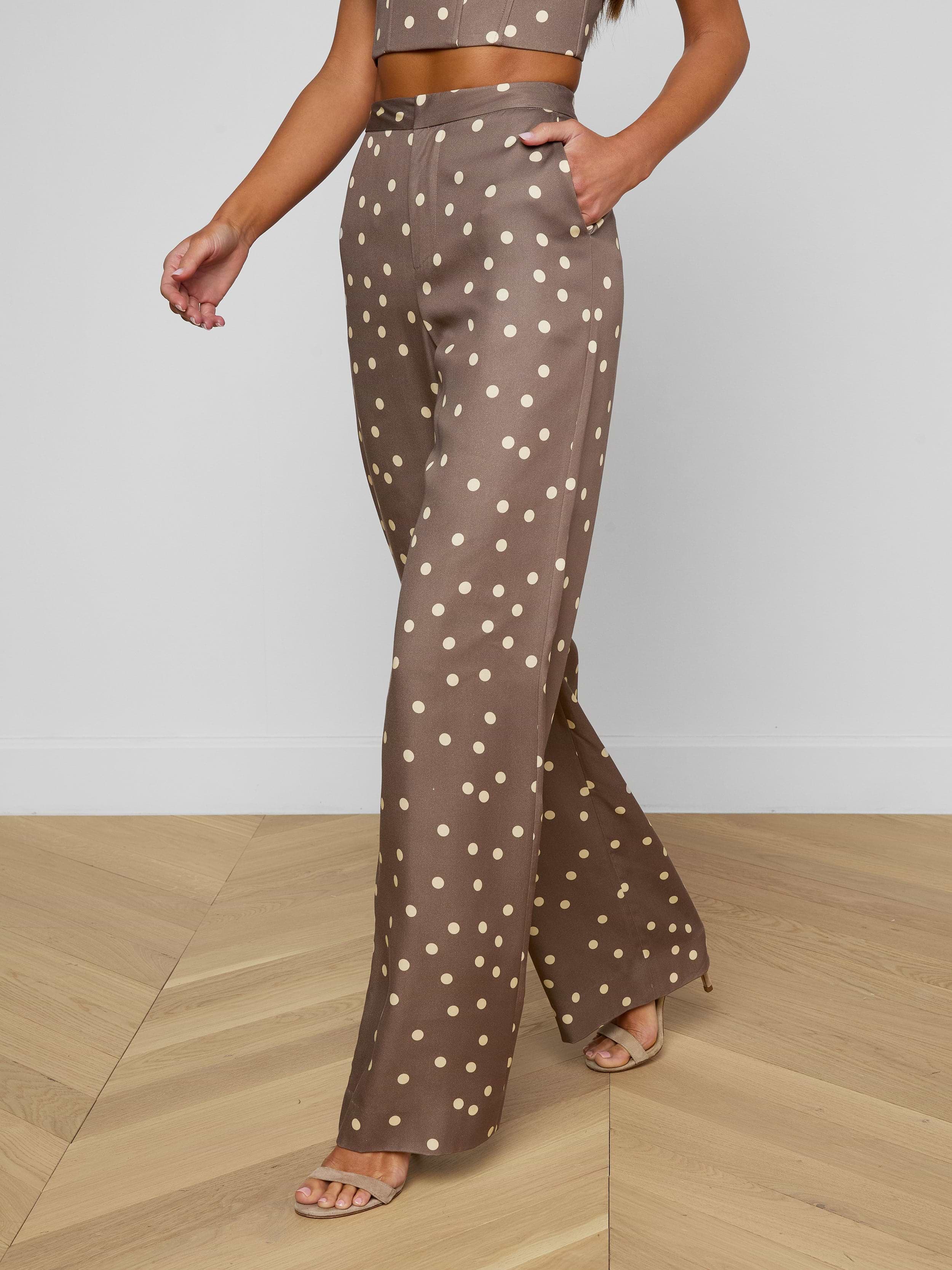 A person wearing the Livvy Straight-Leg Trouser in brown with a white polka dot print, paired with a matching crop top and beige heels, walking against a plain background.