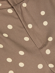 Close-up of brown fabric with a cream polka dot print and a vertical seam through the center, reminiscent of the Livvy Straight-Leg Trouser.