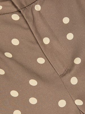 Close-up of brown fabric with large white polka dots and visible seams, featured on the Livvy Straight-Leg Trouser—perfect for a stylish, modern look.