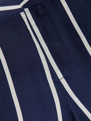 Gros plan sur le pantalon Livvy, avec son tissu Tencel léger, sa teinte marine et ses rayures verticales blanches, sa coupe droite et sa poche latérale soigneusement cousue qui met en valeur la texture et le motif.