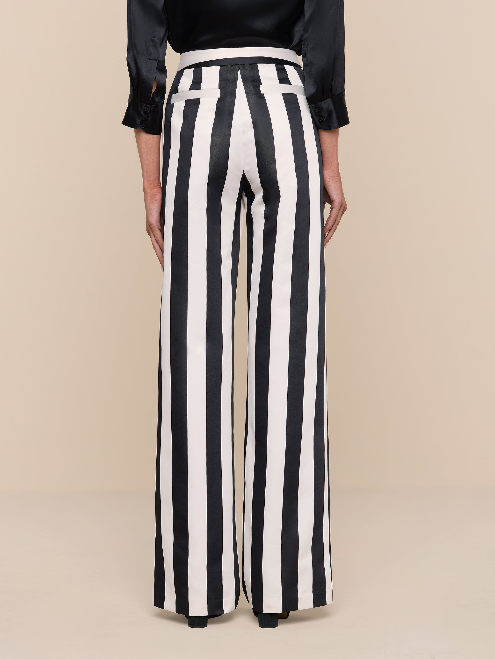 A person is wearing the Livvy Satin Straight-Leg Trouser and a black long-sleeve top, standing against a plain white background, viewed from the back.