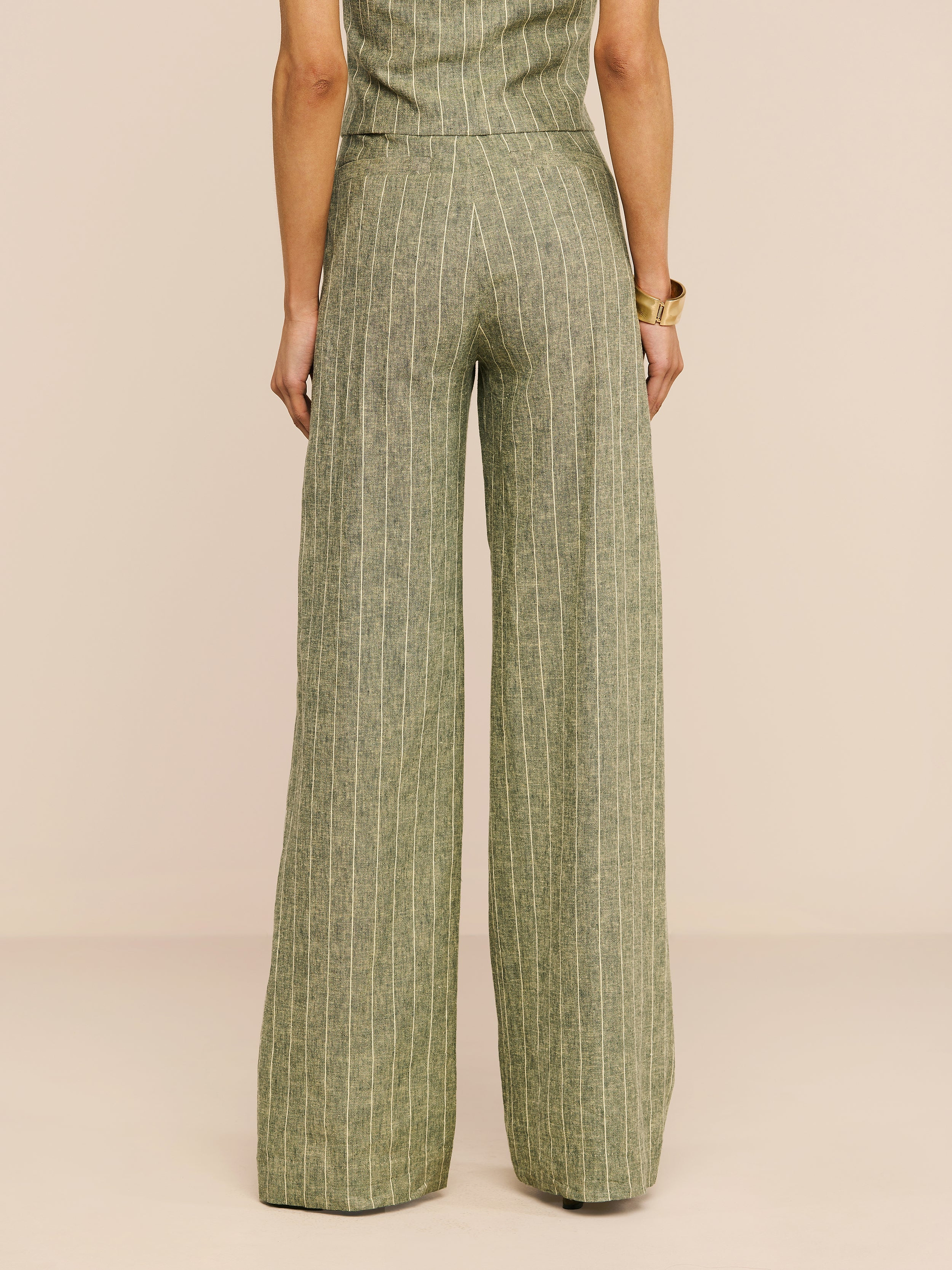 A person stands with their back to the camera, wearing the Livvy Linen-Blend Trouser in olive green with a matching top against a plain white background.