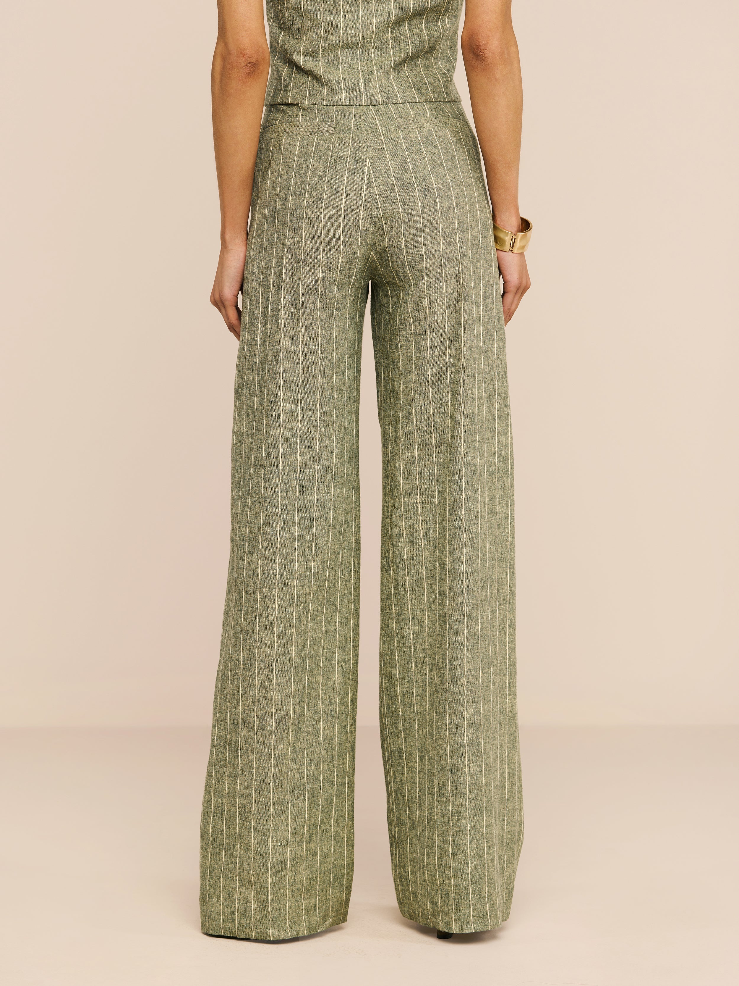 A person stands with their back to the camera, wearing the Livvy Linen-Blend Trouser in olive green with a matching top against a plain white background.