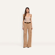 A woman wears a beige tank top and Livvy Suede Straight-Leg Trouser in a business casual style, paired with a brown belt featuring a gold buckle.