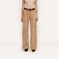 A person wearing beige suede Livvy Suede Straight-Leg Trousers for business casual wear, styled with a brown belt featuring a large gold buckle and brown shoes.
