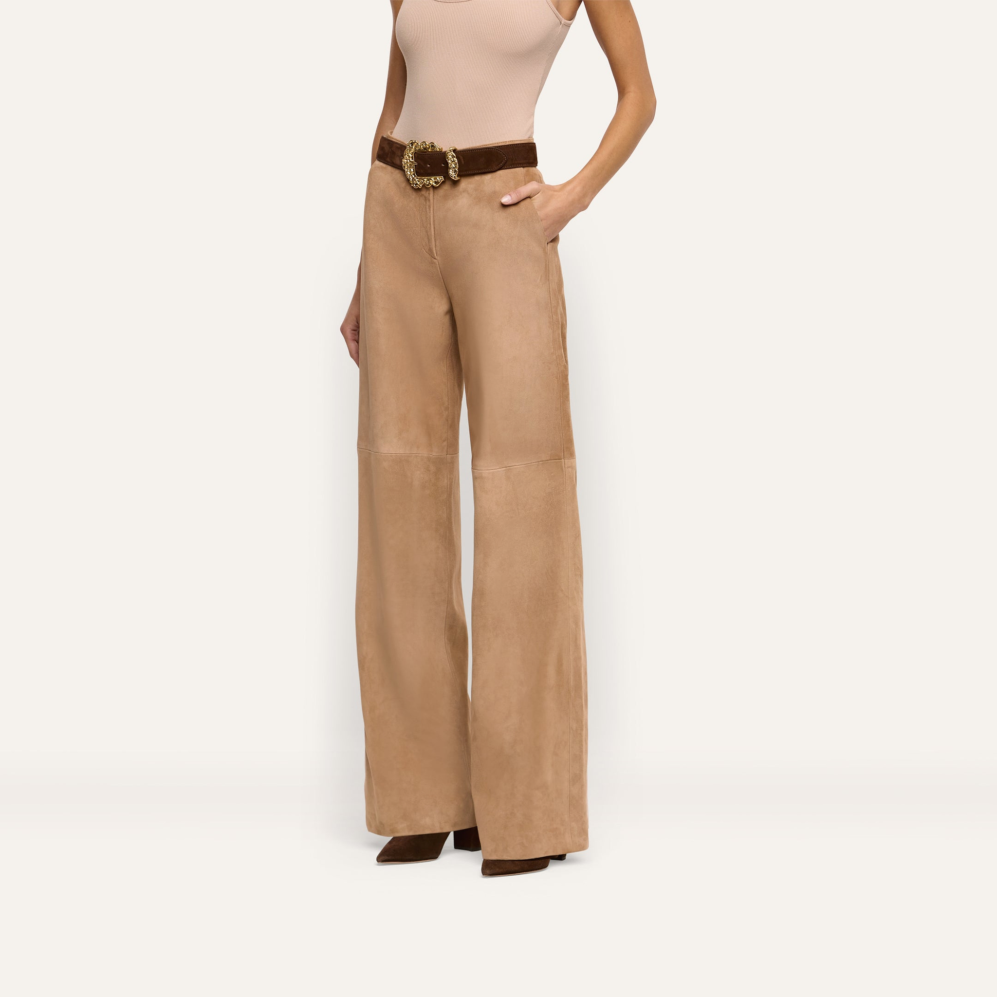 Livvy Suede Straight-Leg Trouser in tan, worn with a brown belt featuring a large gold buckle.