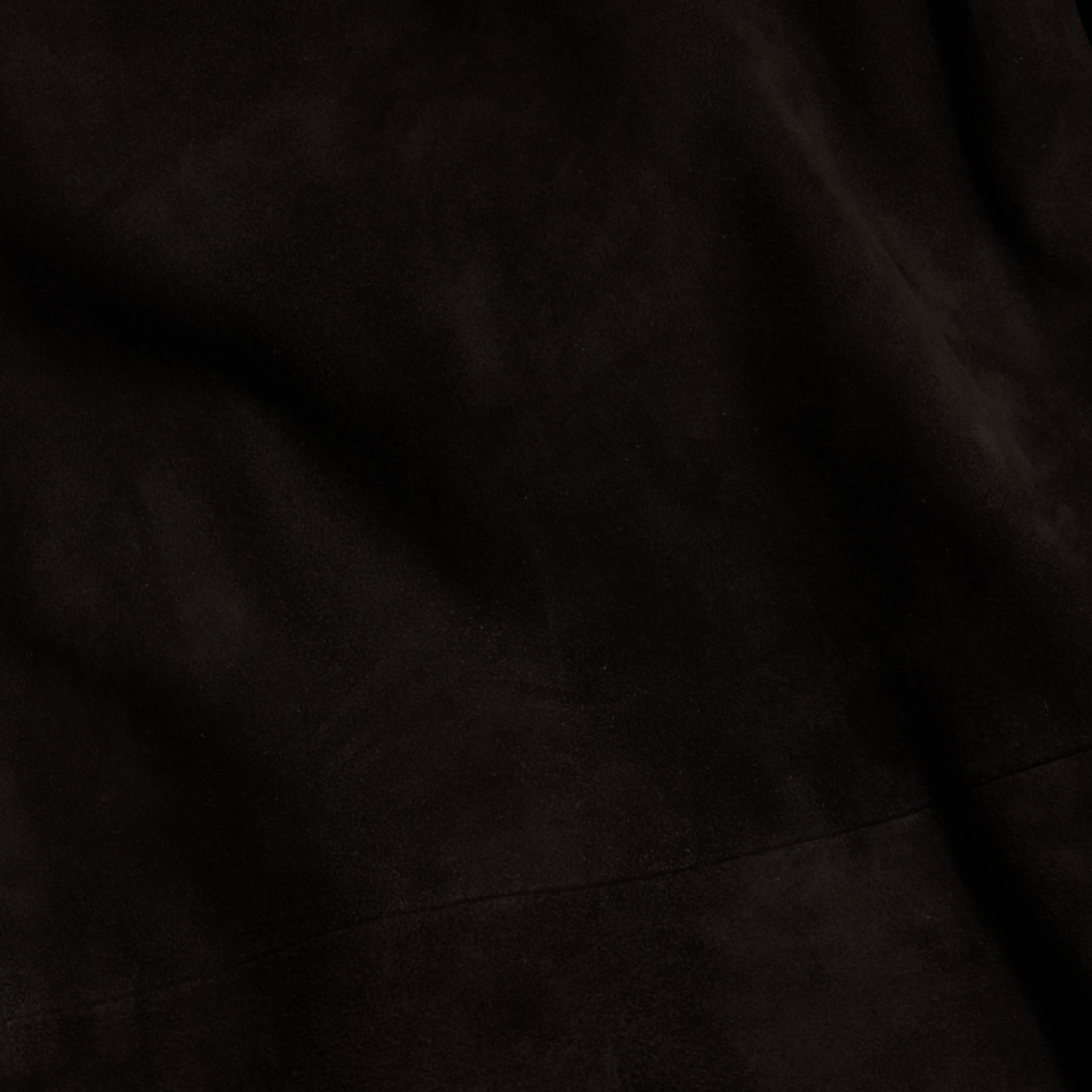 Close-up of a dark, textured fabric with subtle folds and shading, giving the surface a soft, velvety appearance reminiscent of the Livvy Suede Trouser for Fall 2026.