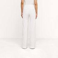 A person is shown from the back, standing against a white background, wearing high rise white Livvy Trouser and a white top.