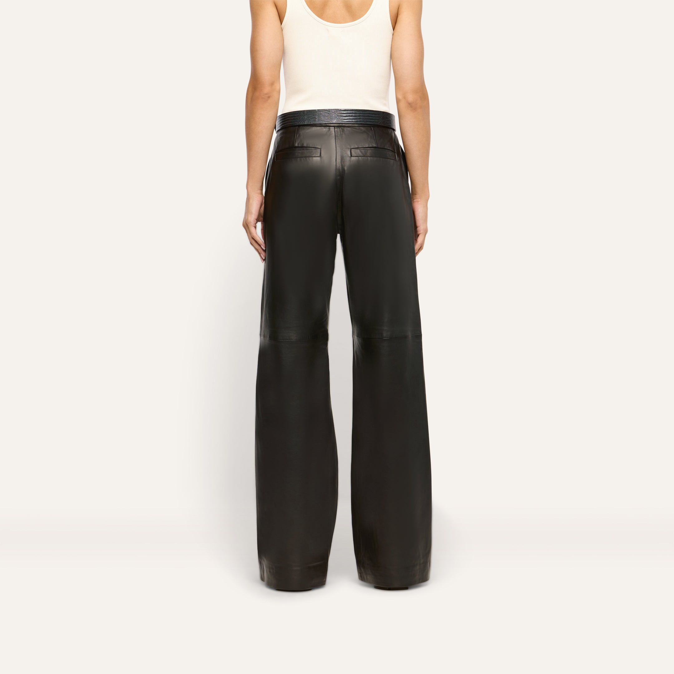 Back view of a person wearing a white tank top and the white Livvy Leather Trouser, featuring a lightweight lambskin leather wide-leg fit.