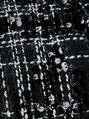 Close-up of Livvy Tweed Trouser by L'AGENCE, featuring textured black and white plaid tweed adorned with shiny black sequins—ideal for crafting a sophisticated statement look.