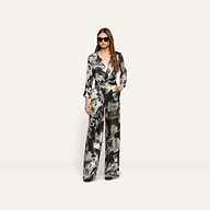 A woman wearing a matching button-down shirt and Livvy Silk Straight-Leg Trouser in a black-and-white magazine print with sunglasses.
