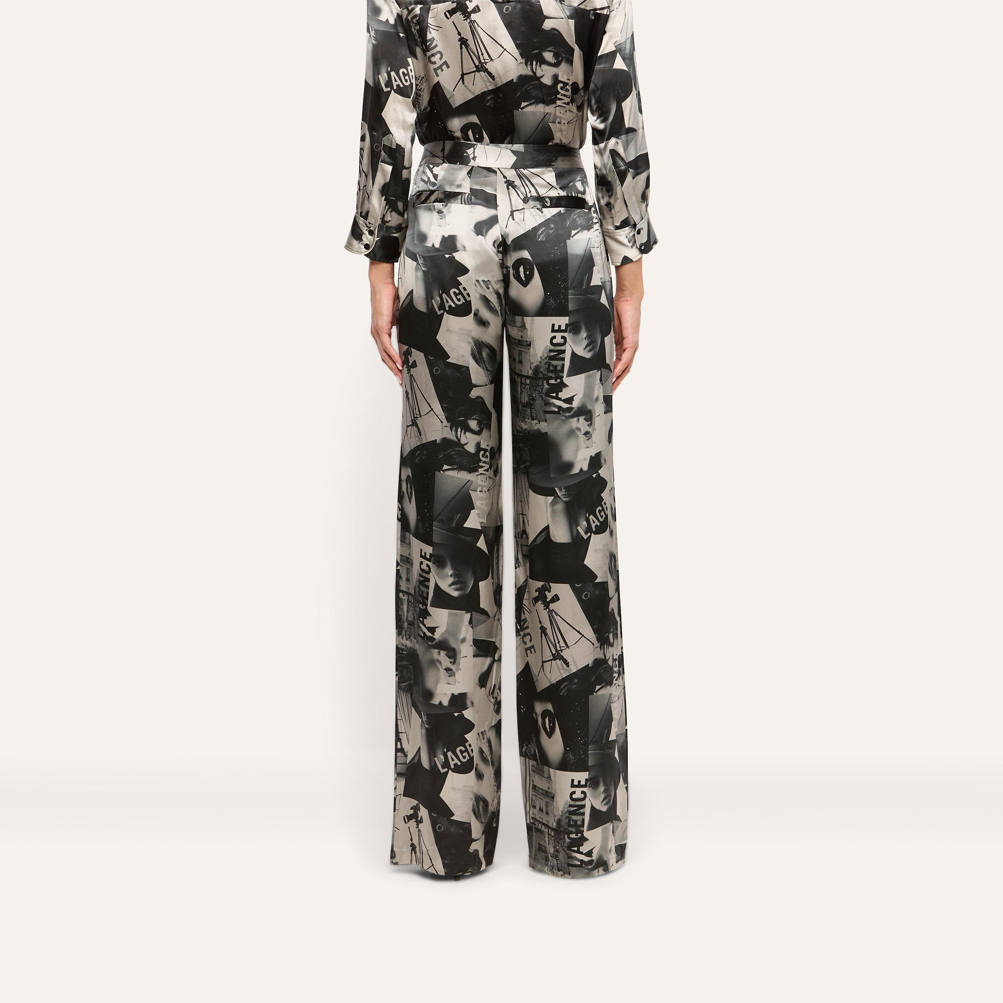 Back view of the Livvy Silk Straight-Leg Trouser in 100 silk featuring a black and white magazine print of faces and text.