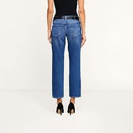 A person stands facing away, wearing a black sleeveless top, the Nevia Slouchy Straight-Leg Jean in vintage-inspired blue high-waisted all-cotton denim, and black high-heeled shoes against a plain white background.