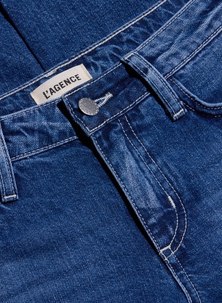 Close-up of the Nevia Slouchy Straight-Leg Jean in a blue, medium-dark wash with contrast stitching, silver button, belt loops, and a LAGENCE label near the waistband. These vintage-inspired jeans feature classic details and a relaxed slouch fit silhouette.