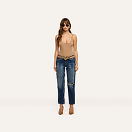 A person wears a beige tank top and Nevia Slouchy Straight-Leg Jean with a distressed knee, belted at the waist with brown pumps for an off-duty look.