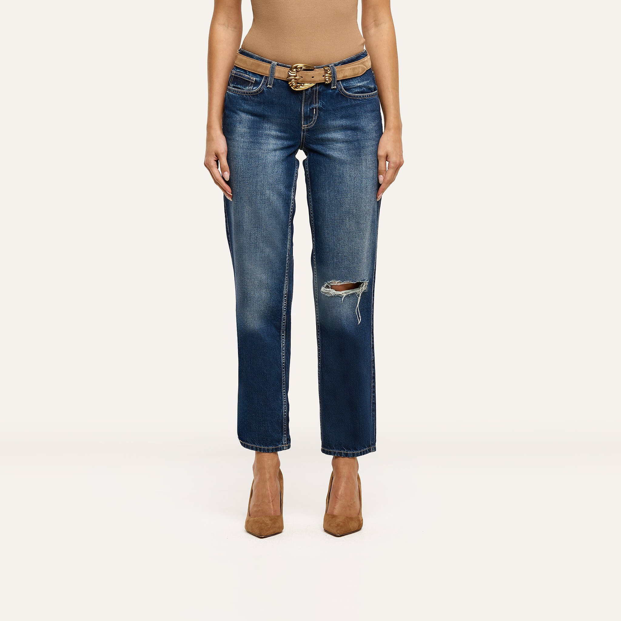 Nevia Slouchy Straight-Leg Jeans in an indigo wash with a distressed knee, worn with a tan belt and pointed-toe heels.