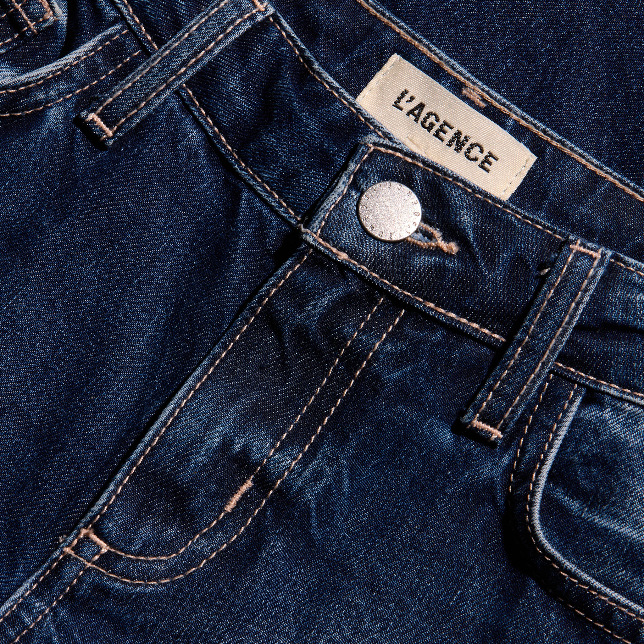 Nevia Slouchy Straight-Leg Jean in dark blue indigo wash with a slouch fit, featuring contrast stitching, a metal button closure, and a brand label at the waistband.