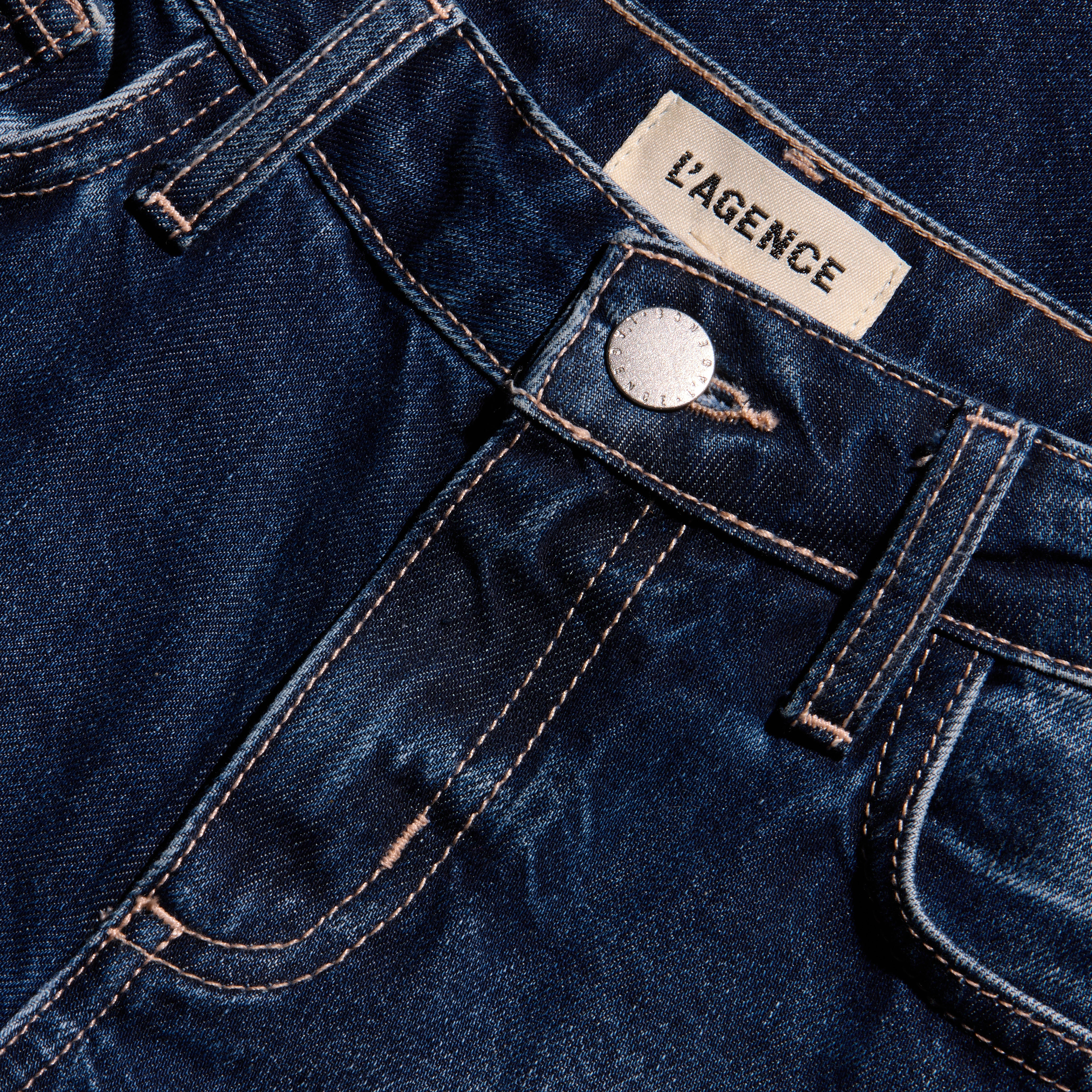 Nevia Slouchy Straight-Leg Jean in dark blue indigo wash with a slouch fit, featuring contrast stitching, a metal button closure, and a brand label at the waistband.