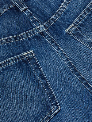 Close-up of blue denim fabric with two back pockets, visible stitching, seams, and a faded texture typical of L'AGENCE Jones Stovepipe Jean high-rise straight leg all-cotton jeans.