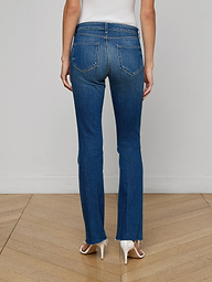 A person wearing the Sneeki Low-Rise Straight-Leg Jean stands facing away from the camera, showcasing the back pockets of the jeans against a plain, light background while paired with tan heels.