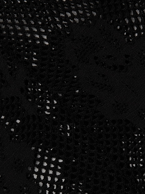 Close-up of Josiane Floral Lace Legging in black, featuring an intricate floral pattern and sheer netting. Light filters through the delicate, fashion-forward design, highlighting the textured details of this stylish legging.