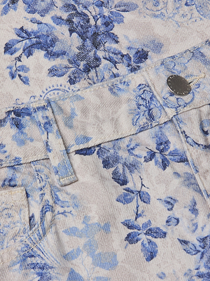 Close-up of the June Cropped Stovepipe Jean, a light-colored, high-rise straight leg style with a blue floral print, belt loops, a silver button, and part of a pocket visible.