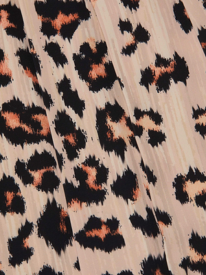 Close-up of leopard print fabric in black and orange on light beige, with softly blurred, irregular edges for a textured effect. Designed for the Nova Pleated Wide-Leg Pant.