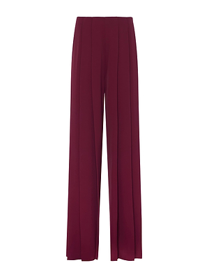 The L'AGENCE Nova Pleated Wide-Leg Pant features a high-rise, wide-leg silhouette in burgundy fluid suiting fabric with front pleats, pictured against a plain white background.