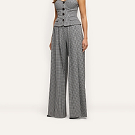 A person wearing a button-front peplum top and matching Nova Pleated Wide-Leg Pant in a black and white gingham suiting fabric.
