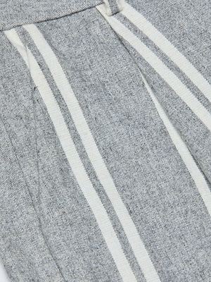 Close-up of the Allanah Striped Trouser in grey Italian wool blend fabric, featuring two vertical white stripes and a visible seam or pocket detail, highlighting its modern, textured design.