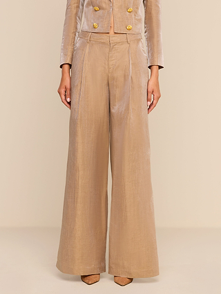 Wearing the Allanah Linen-Blend Trouser in latte brown, styled high-waisted with wide legs and paired with a matching blazer and pointed-toe shoes, a person stands against a neutral background.