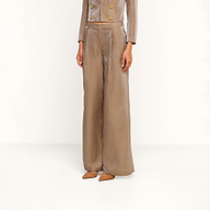 A person is seen against a plain white background wearing the Allanah Linen-Blend Trouser, featuring a high-waisted, wide-leg silhouette in a latte brown shade, paired with a matching double-breasted jacket adorned with gold buttons. The face is not visible.