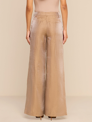 A person wearing the Allanah Linen-Blend Trouser in a high-waisted, wide-leg silhouette and shiny latte brown color, shown from the back against a plain beige background.