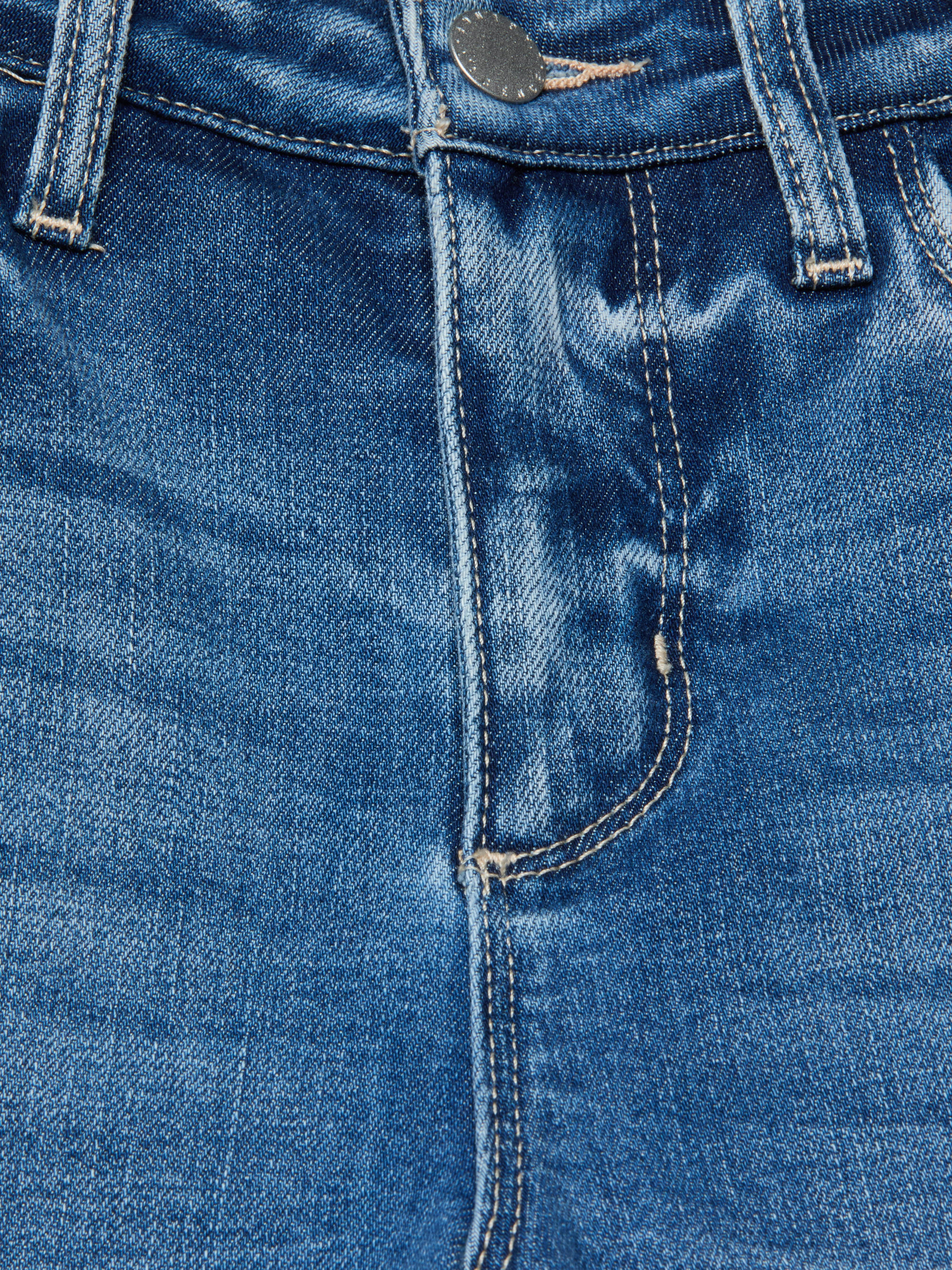 Close-up of the Scottie Wide-Leg Jean in blue denim, highlighting the waistband, button, zipper, belt loops, and detailed stitching. The fabric features slight fading and a textured appearance characteristic of well-worn stretch denim.