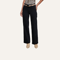 Wearing the Scottie Wide-Leg Jean featuring a contoured waistband, a person styles the black jeans with a beige belt and tan heeled shoes, striking a pose with one hand on their hip against a plain, light-colored background.