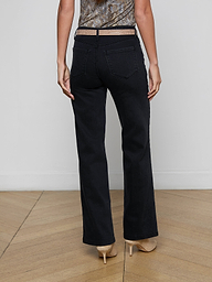 A person is shown from the back, standing against a plain light background, wearing the Scottie Wide-Leg Jean in black with a contoured waistband and beige high heels.