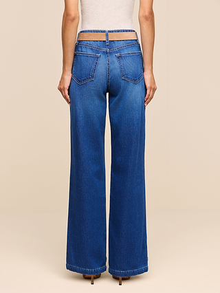 A person wearing the Scottie Wide-Leg Jean, featuring high-waisted, wide-leg blue nonstretch denim and a distinctive double waistband design, viewed from the back. The jeans include two back pockets and a top waistband that sits above the hips.