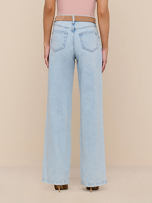 A person faces away wearing Scottie Wide-Leg Jean in light wash and a sleeveless pink top, set against a beige background.