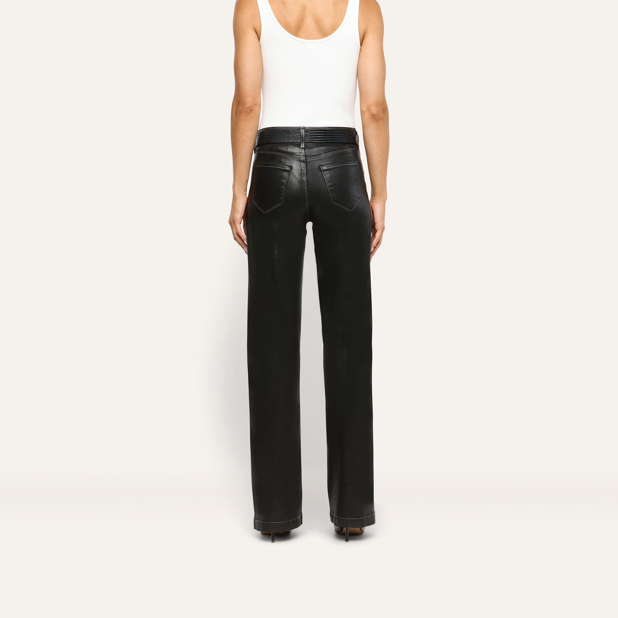 Back view of a person wearing a white tank top and Scottie Coated Wide-Leg Jean, featuring high-rise, wide-leg coated denim trousers with a belted waist.