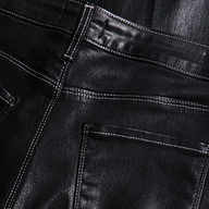 Close-up of the back pockets and high-rise waistband of black Scottie Coated Wide-Leg Jean with visible stitching.
