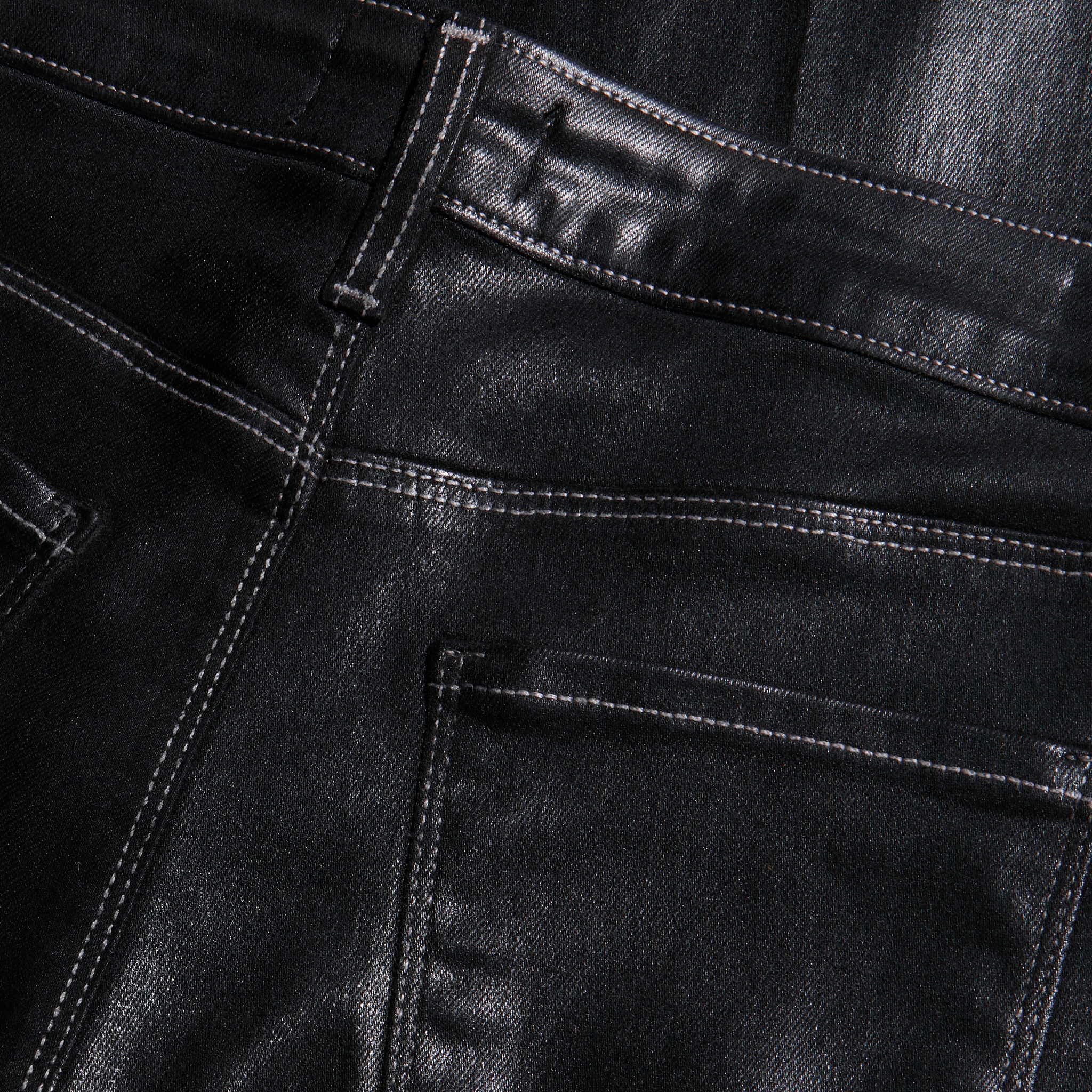 Close-up of the back pockets and high-rise waistband of black Scottie Coated Wide-Leg Jean with visible stitching.