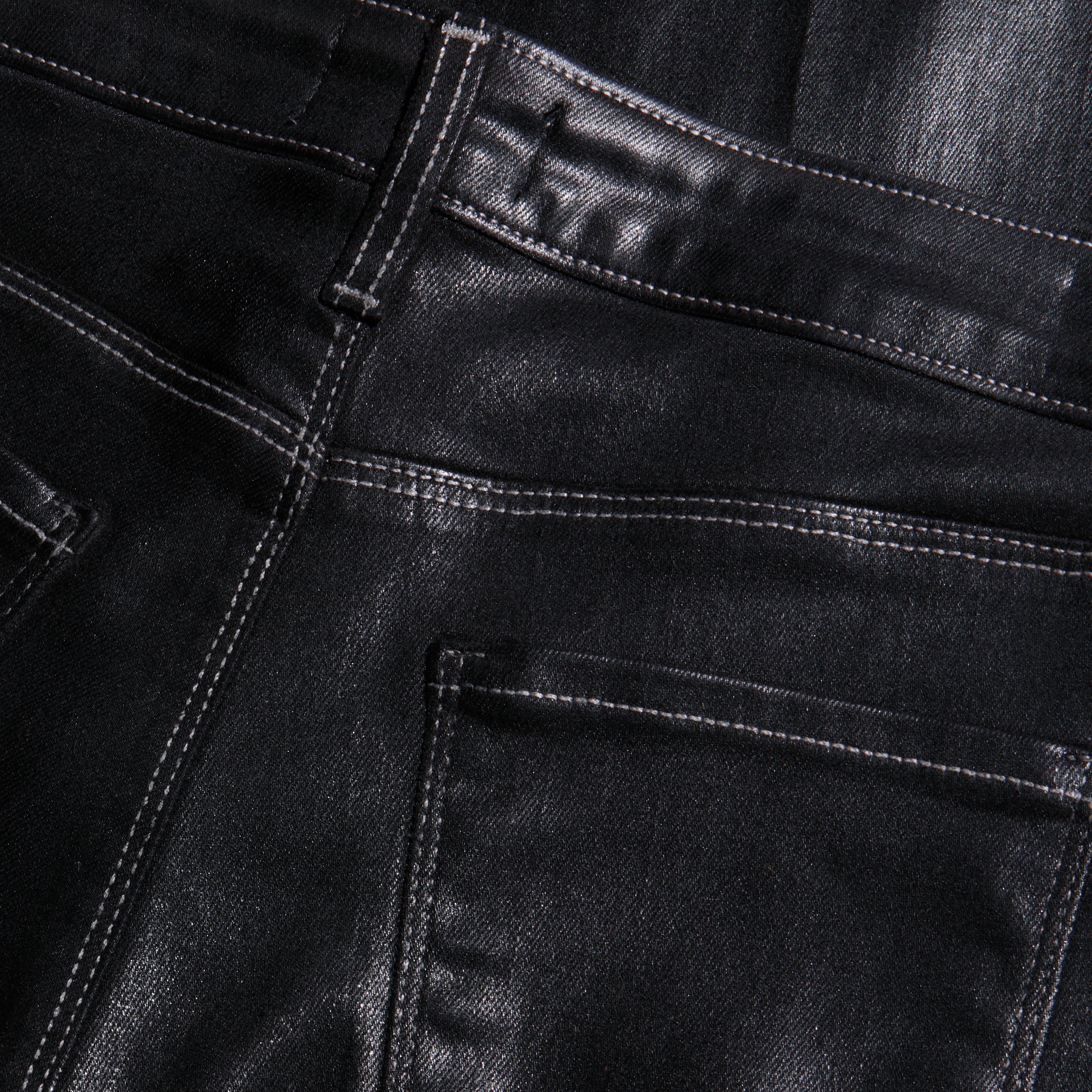 Close-up of the back pockets and high-rise waistband of black Scottie Coated Wide-Leg Jean with visible stitching.