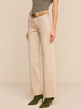 A woman stands against a neutral background wearing the Scottie Coated Wide-Leg Jean in beige, styled with a brown belt, a sleeveless olive top, and olive green pointed-toe boots. Her face is not visible.