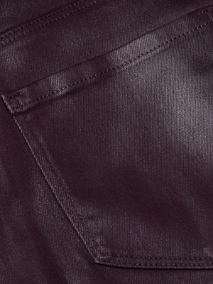 Close-up of the shiny, dark-coated denim fabric on the L'AGENCE Scottie Coated Wide-Leg Jean, highlighting stitching and seam details on the back pocket.